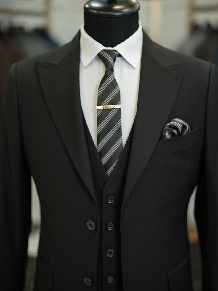 XAYWEAR black three piece suit with white dress shirt and striped tie on mannequin