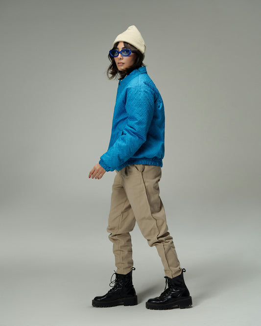 XAYWEAR blue winter jacket worn by model with beige pants black boots and white beanie