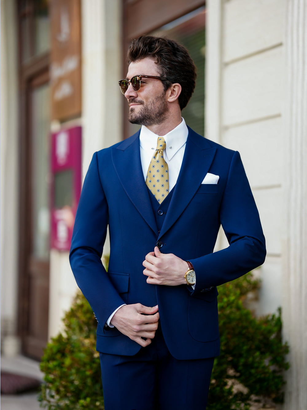 XAYWEAR navy blue suit with vest and yellow tie formal wear for men in outdoor setting