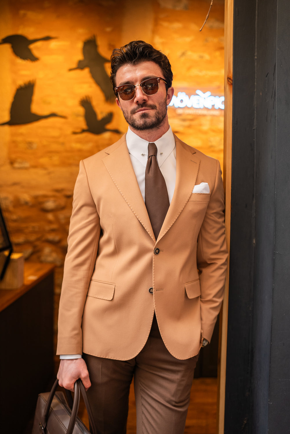 XAYWEAR stylish suit for men in tan blazer with matching brown pants and tie, accessorized with sunglasses