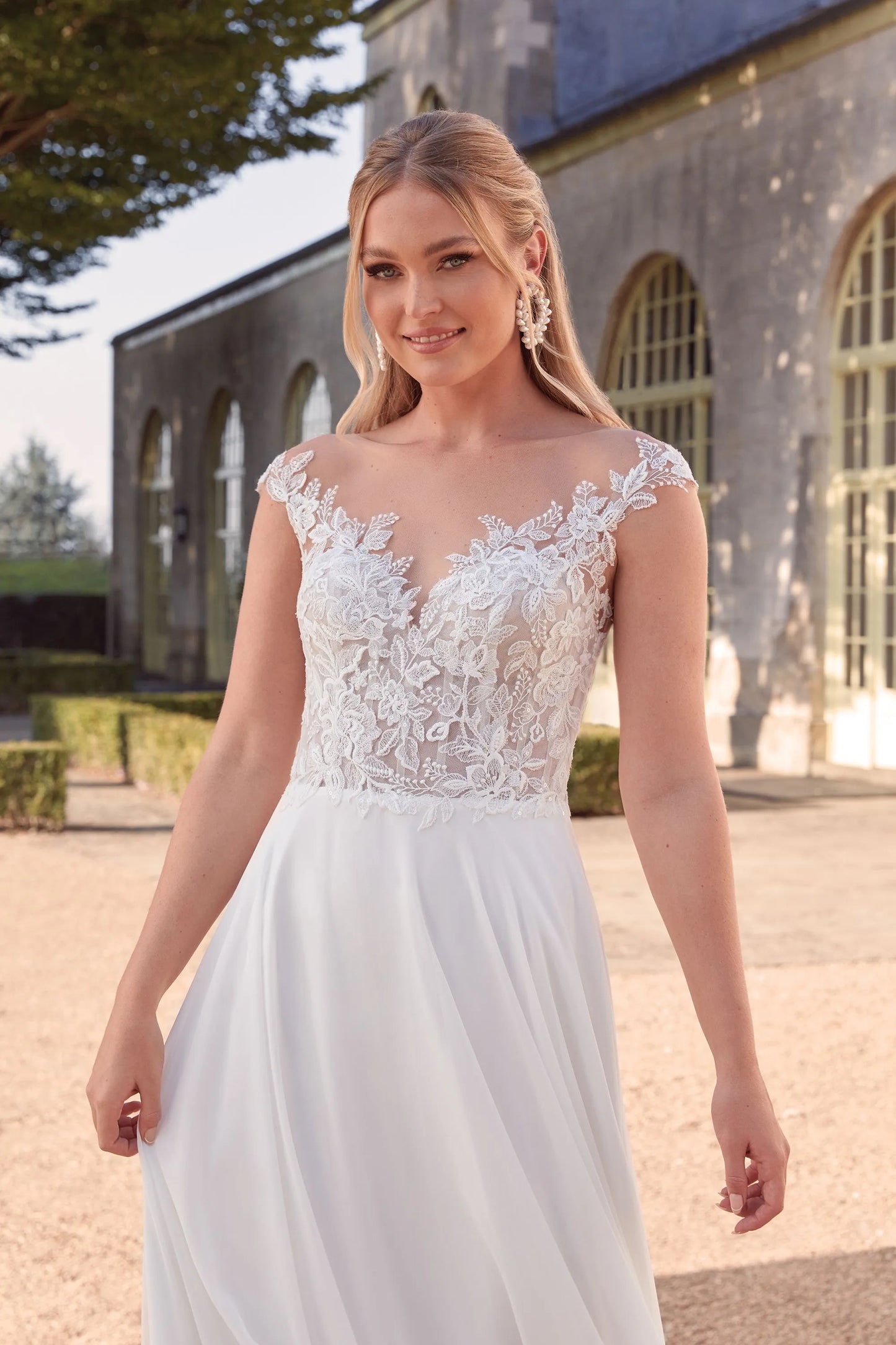 XAYWEAR chiffon wedding dress with lace bodice and flowing skirt worn by smiling bride outdoors