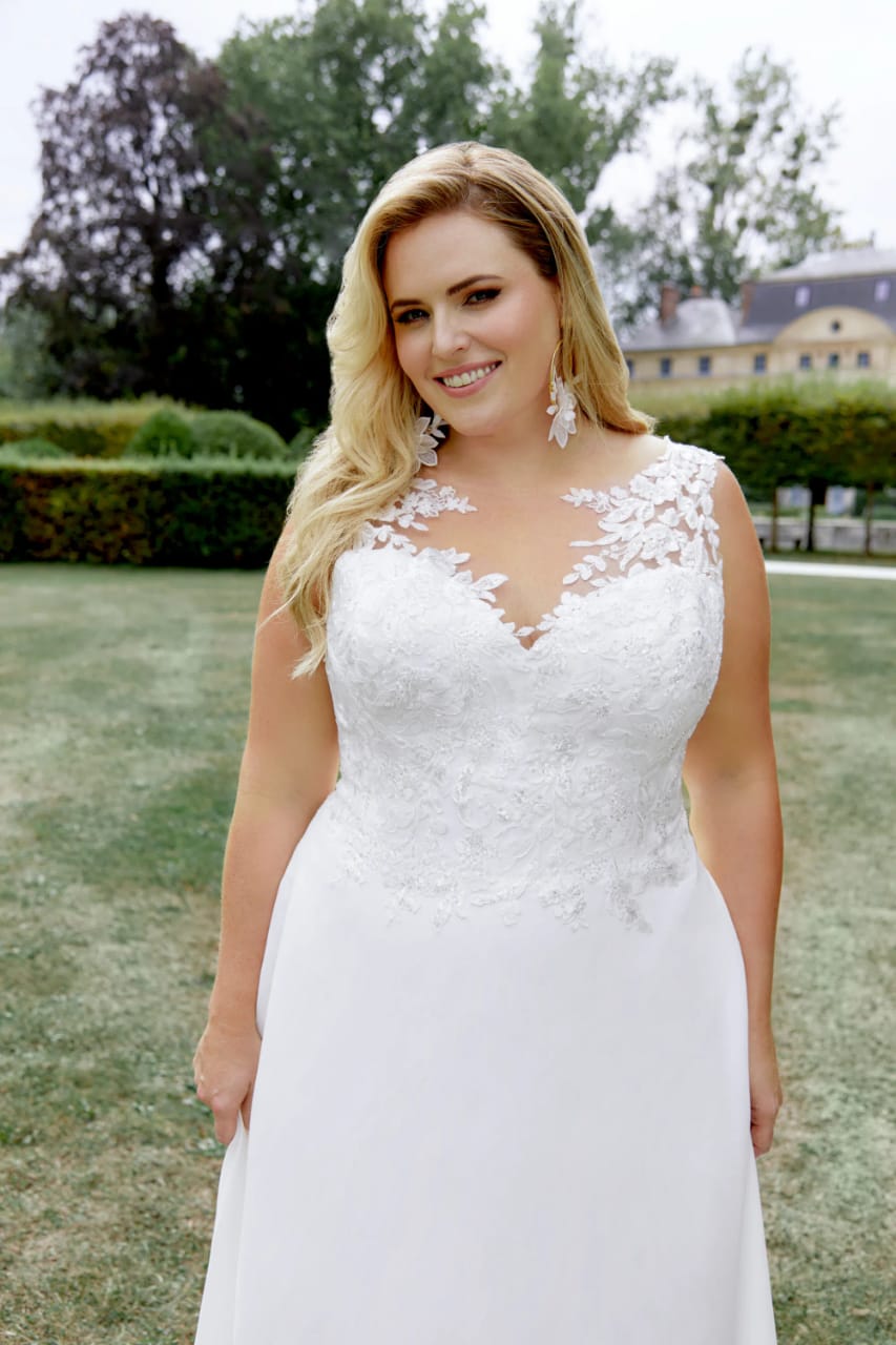 XAYWEAR chiffon wedding gown with lace bodice and sheer floral neckline worn by smiling bride outdoors
