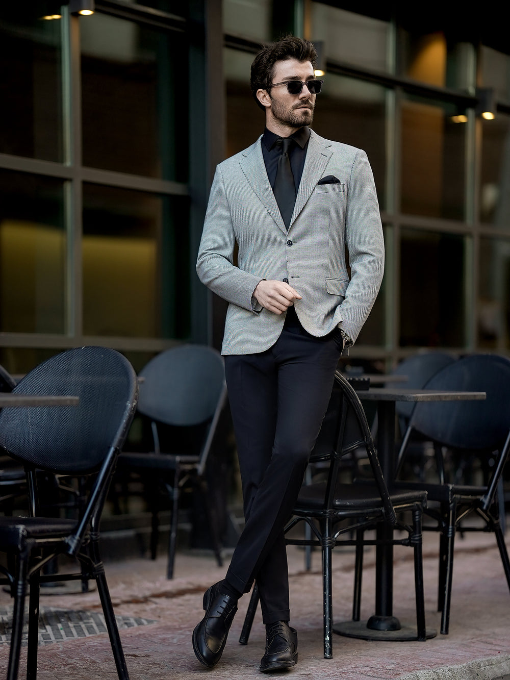 Man wearing stylish two piece suit for men in gray blazer and black pants with black dress shoes