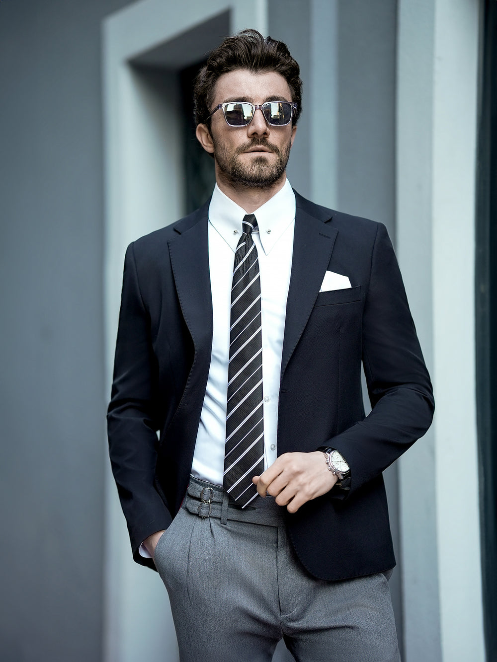 XAYWEAR black suit jacket with gray pants men's business attire styled with striped tie and sunglasses