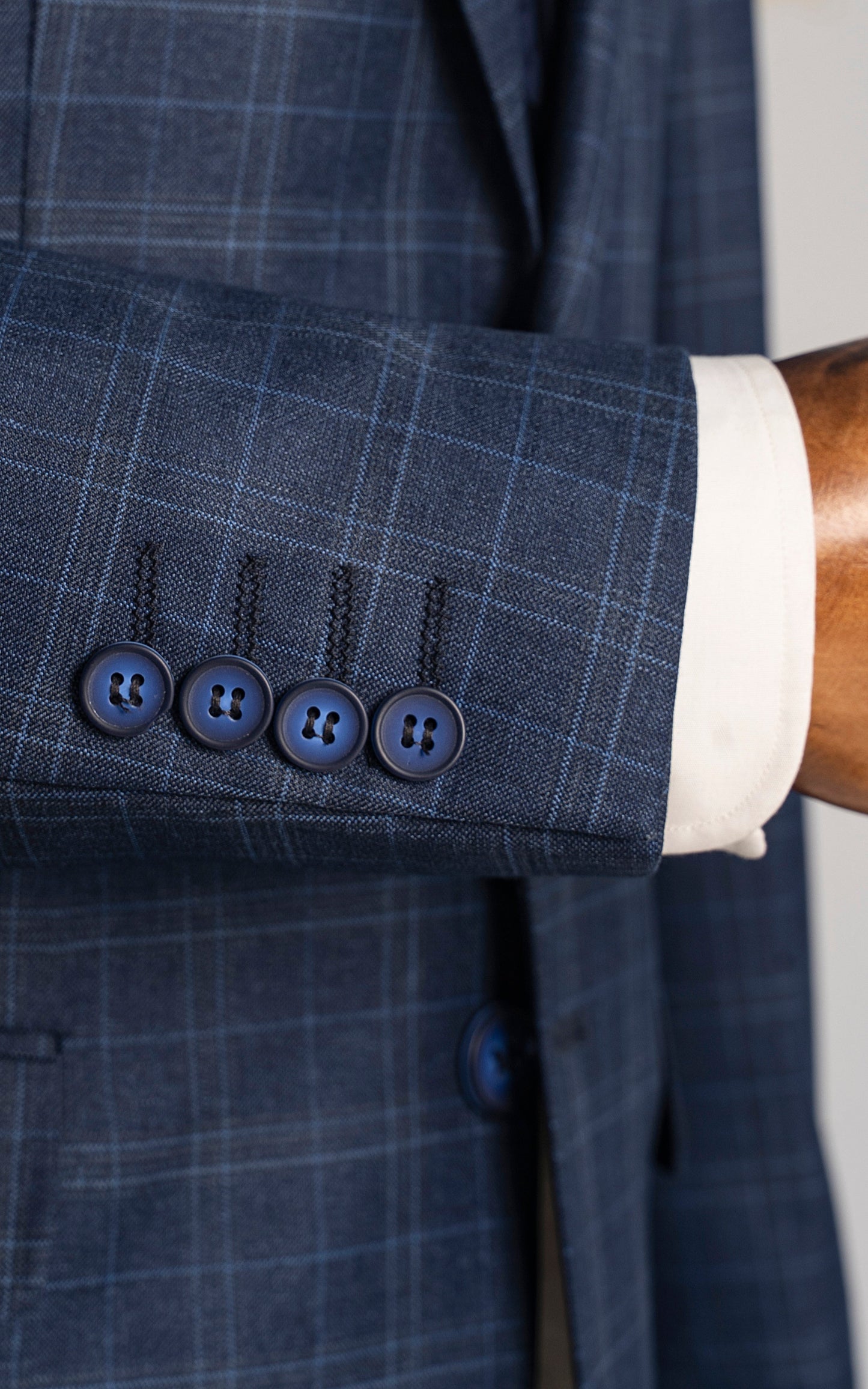 Close-up of XAYWEAR navy blue suit for men showcasing detailed button design and premium fabric