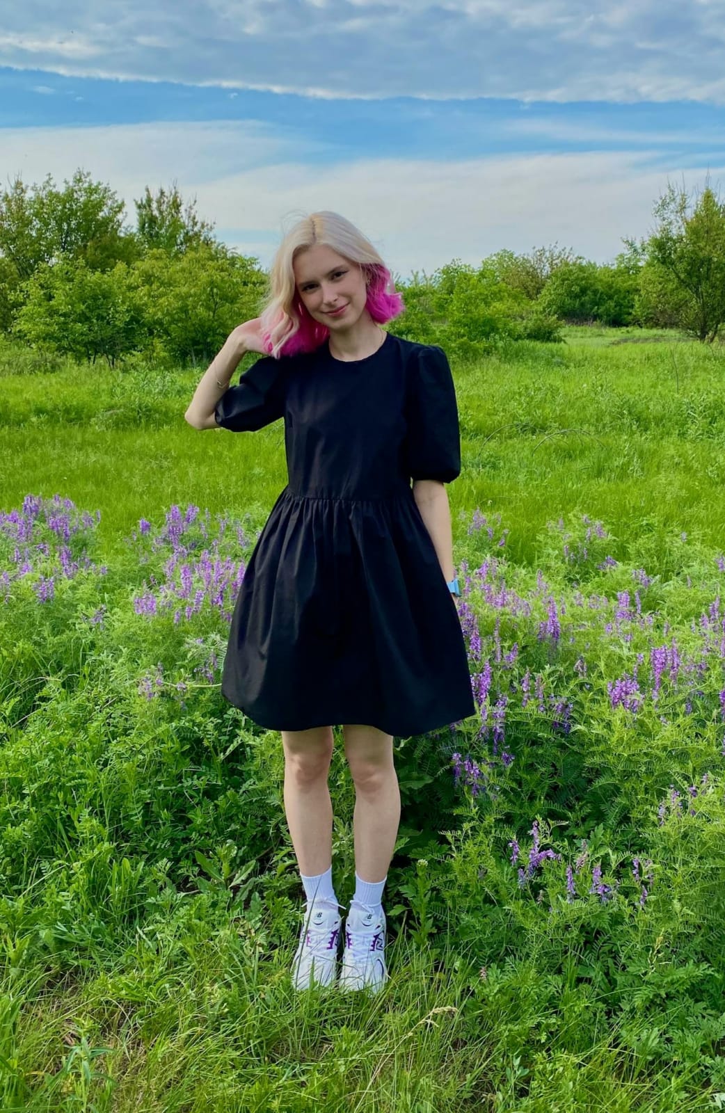 Puff sleeve black dress by XAYWEAR showcased in a green field with flowers