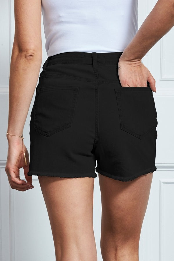XAYWEAR black denim shorts for women with frayed hem and back pockets shown from the rear