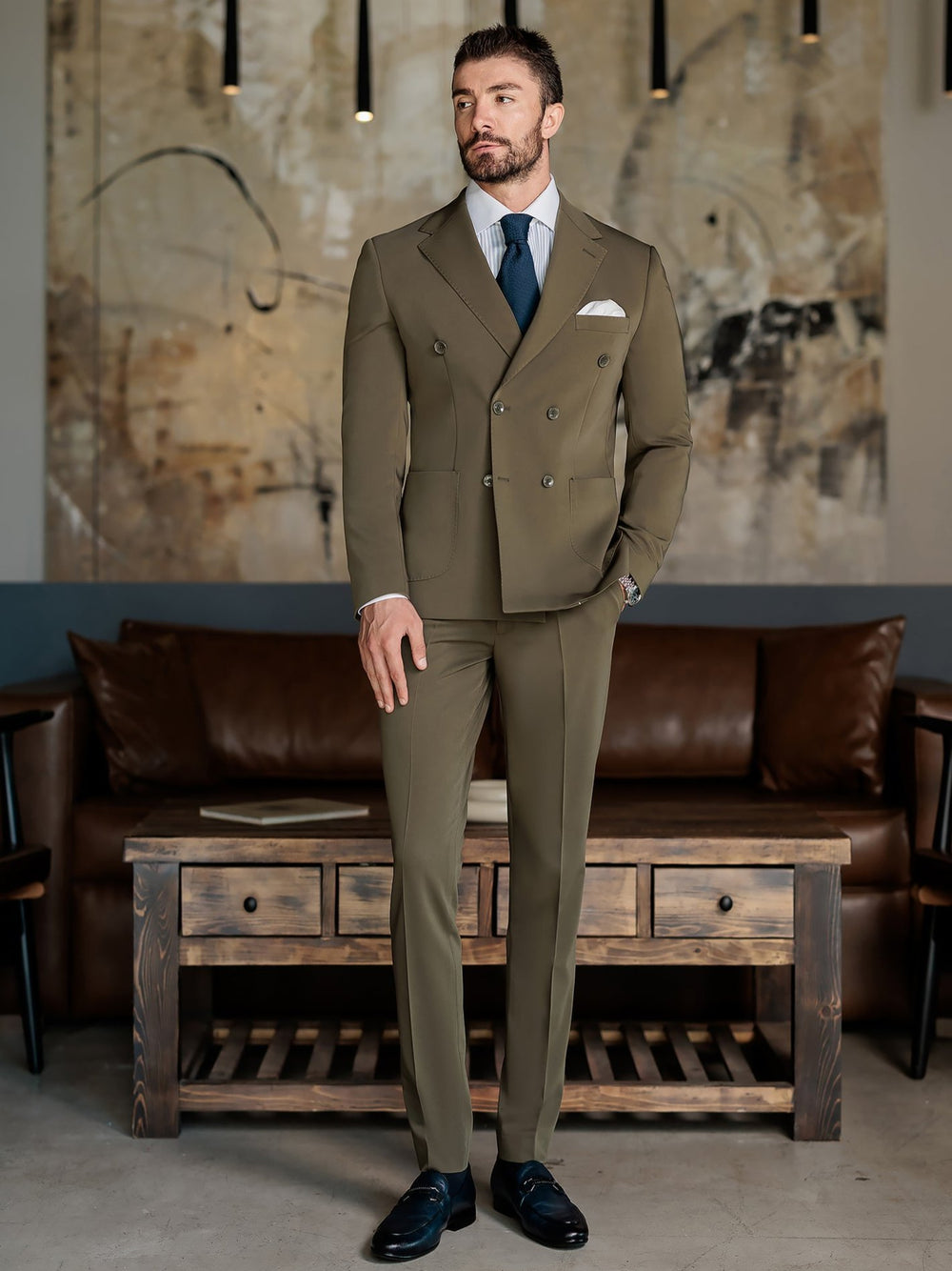 XAYWEAR olive double-breasted suit for men styled with white shirt and navy tie in modern room