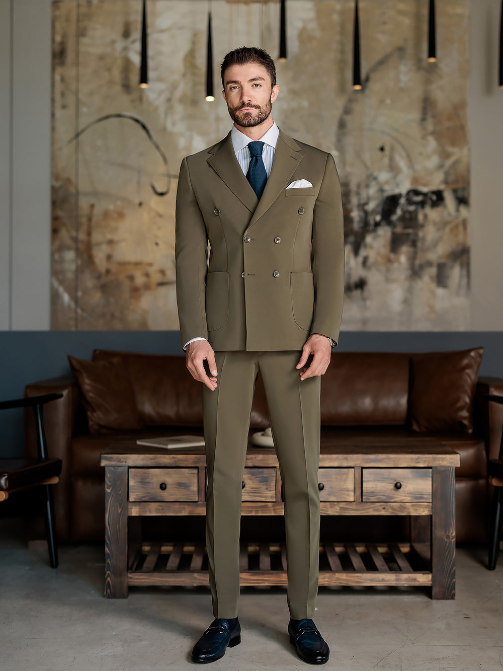 Man wearing an olive green double-breasted suit for men with a white shirt and navy tie by XAYWEAR