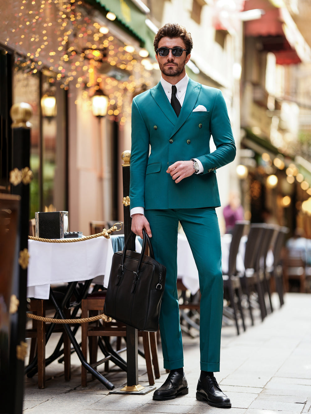 Man wearing a stylish teal double-breasted suit for men by XAYWEAR with black shoes and sunglasses