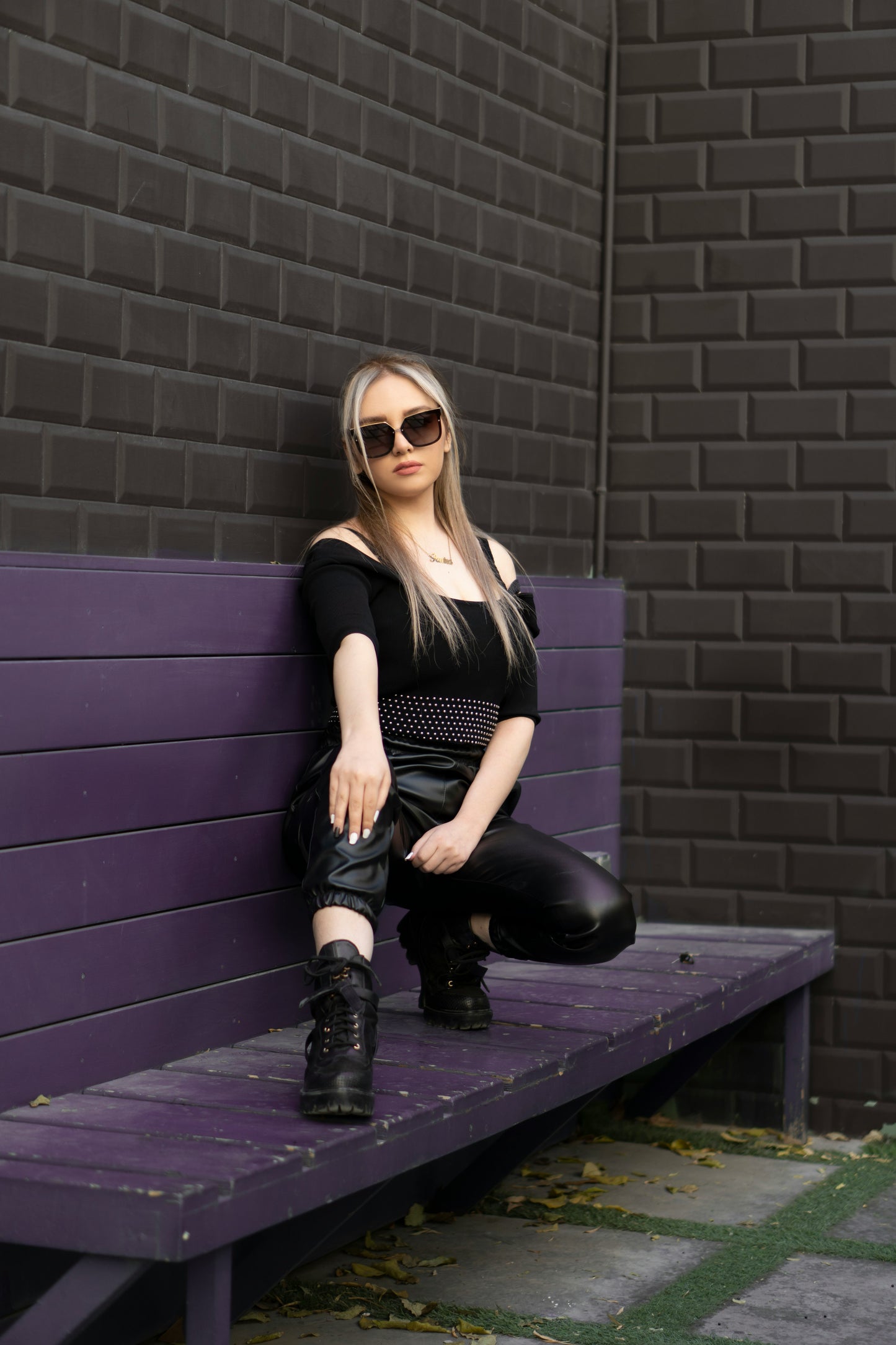 Woman wearing XAYWEAR Faux Leather Joggers for Women Trendy Comfort seated on purple bench outdoors