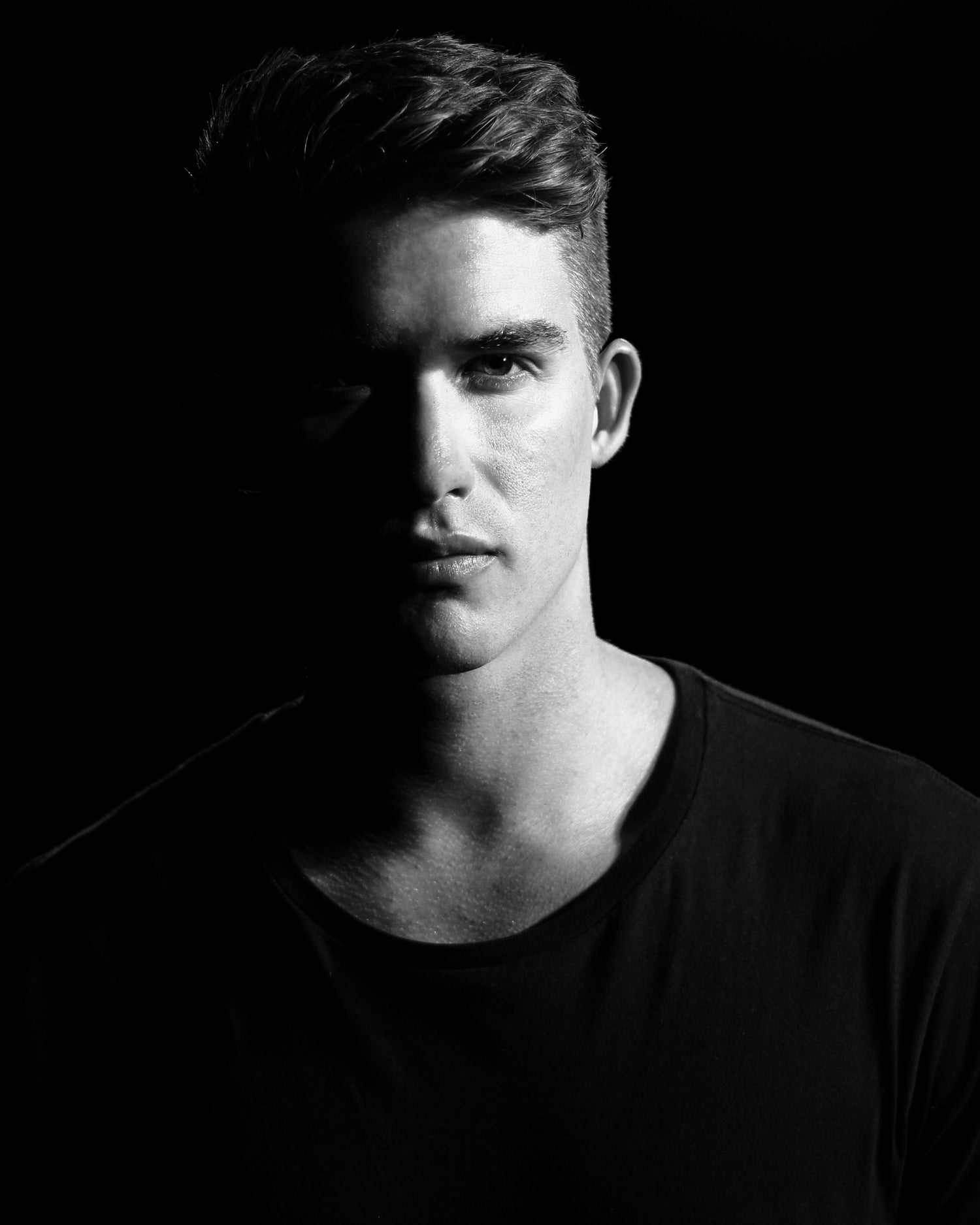 Portrait of a young man in black shirt representing the modern wardrobe for men collection