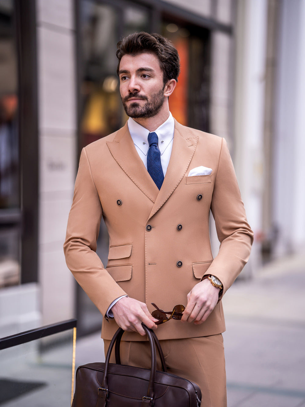 XAYWEAR tan double-breasted suit for men with white shirt and blue tie carrying brown leather bag