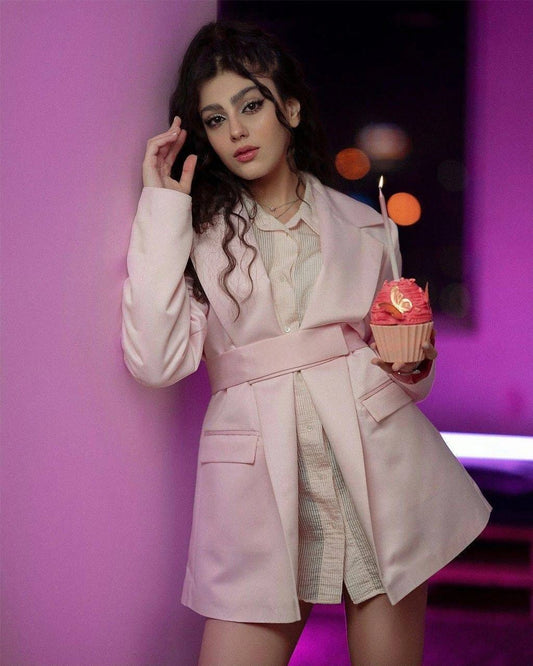 Stylish belted pink jacket for women worn over a light dress, perfect for fashionable outings