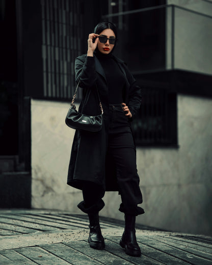 Stylish black coat for women by XAYWEAR worn with sunglasses and black outfit in urban setting