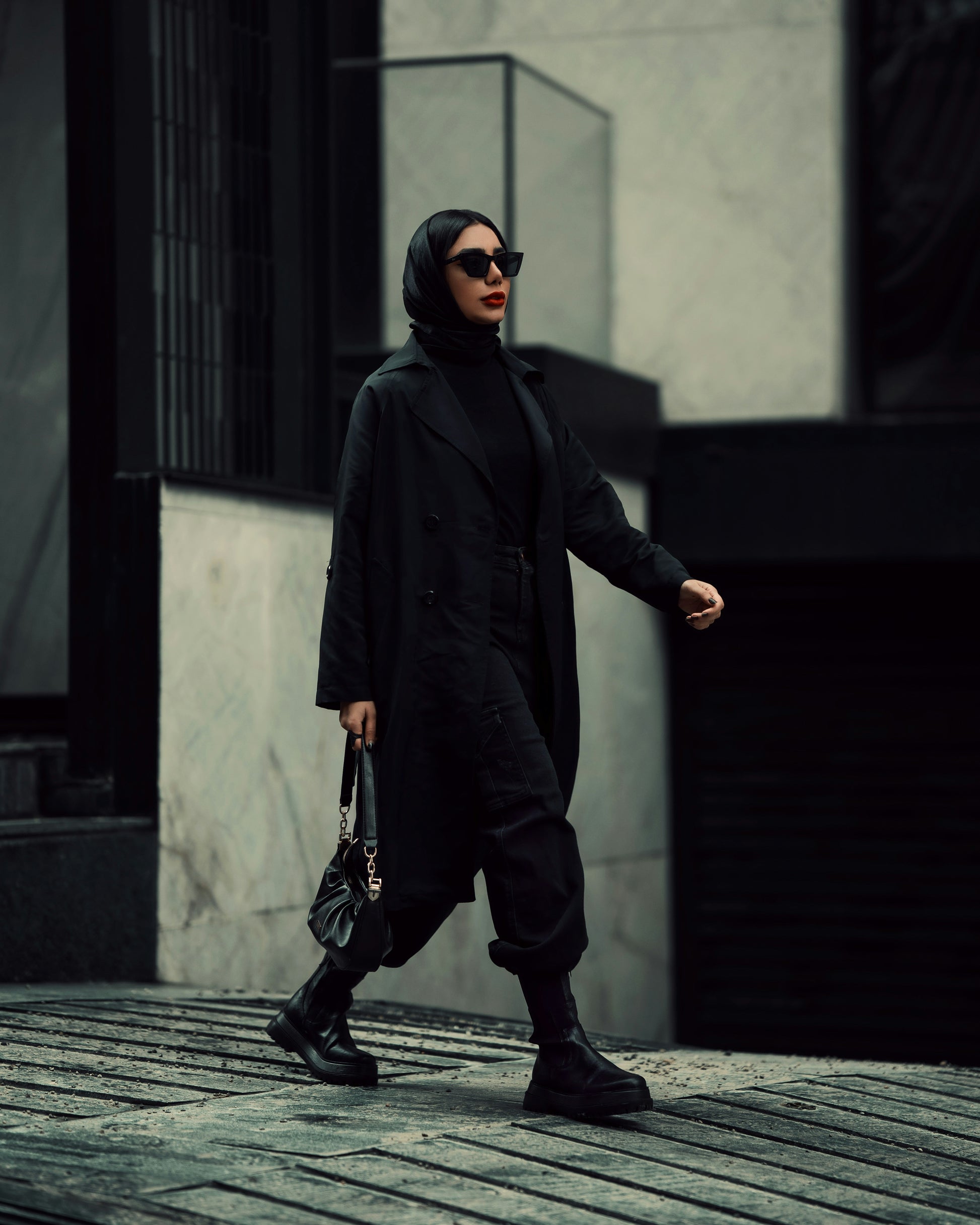 Elegant black coat for women by XAYWEAR styled with black boots and sunglasses on city street
