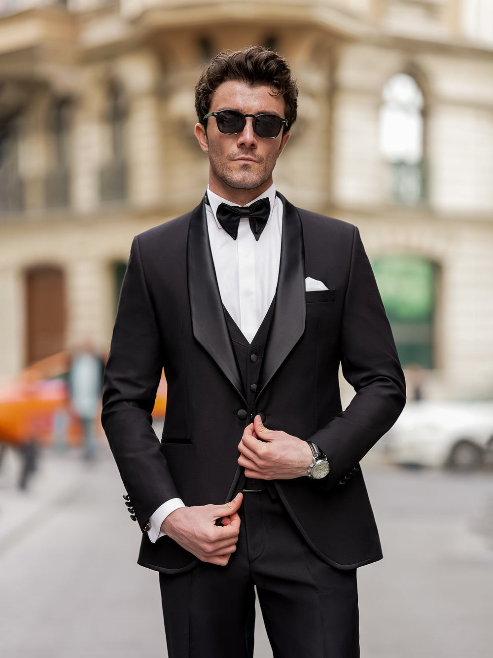 XAYWEAR black men suit with satin lapel, white shirt, black bow tie, and sunglasses on a street background
