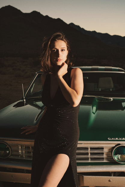 XAYWEAR black slit dress worn by woman posing on vintage green car with mountain background