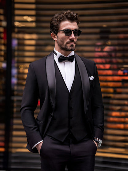 Stylish man wearing a black suit for men by XAYWEAR with a bow tie and sunglasses