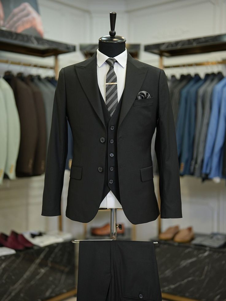XAYWEAR black tailored three piece suit with vest and striped tie on mannequin