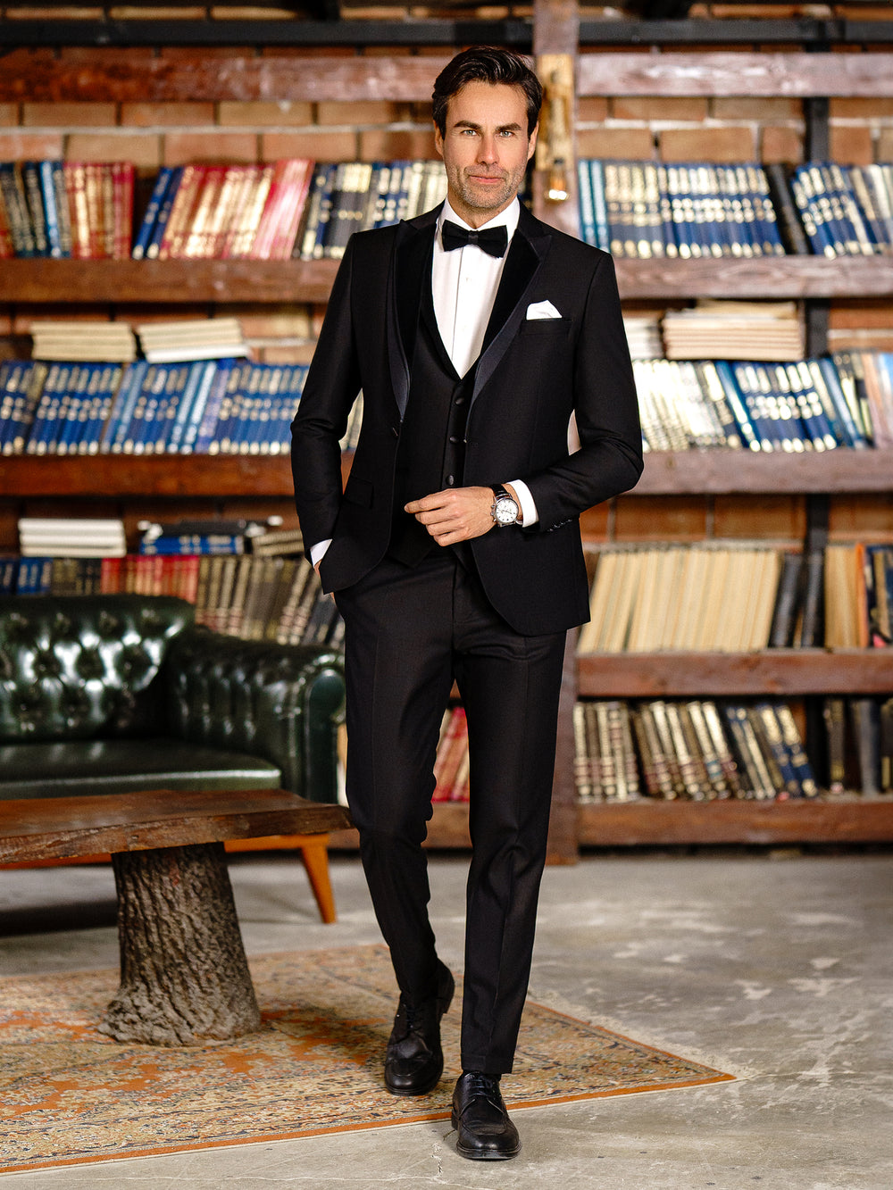 XAYWEAR black suit for men with bow tie and pocket square in a library setting
