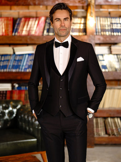 XAYWEAR black tuxedo suit for men with bow tie, white shirt, and pocket square in library setting