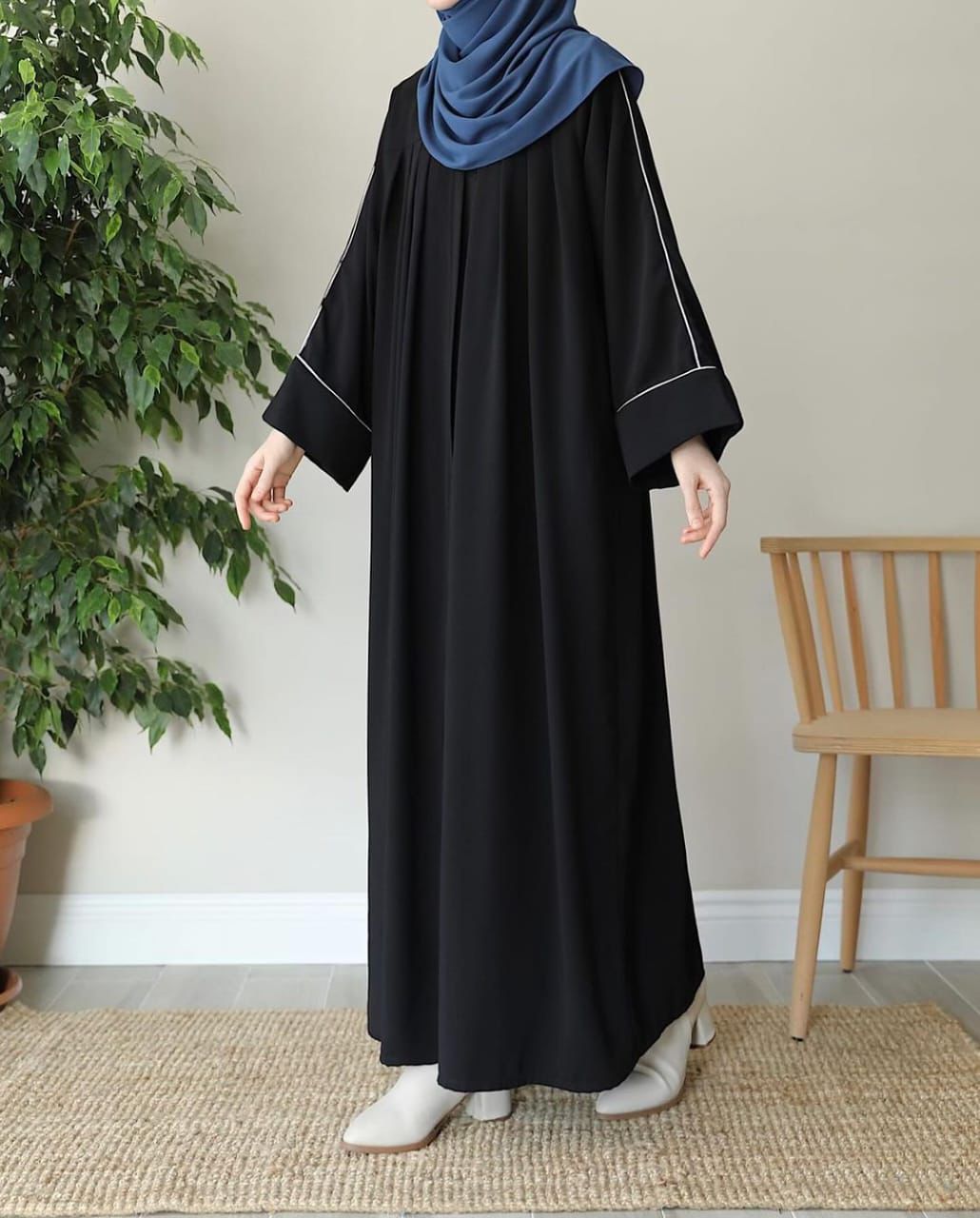 Elegant black zip neck abaya featuring a flowing design and complementary blue hijab