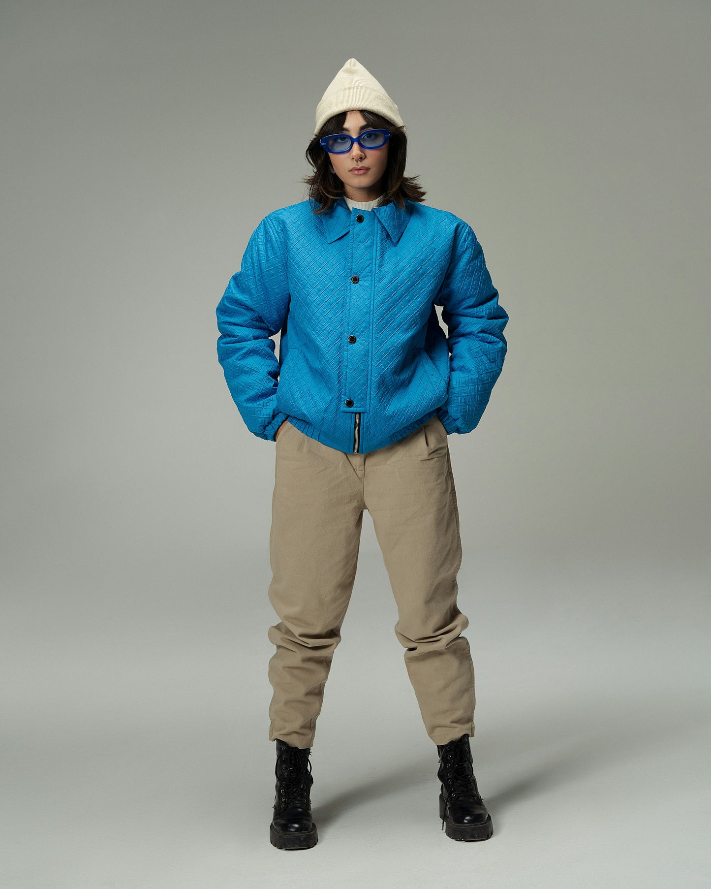 XAYWEAR blue quilted winter jacket worn with beige pants black boots and white hoodie