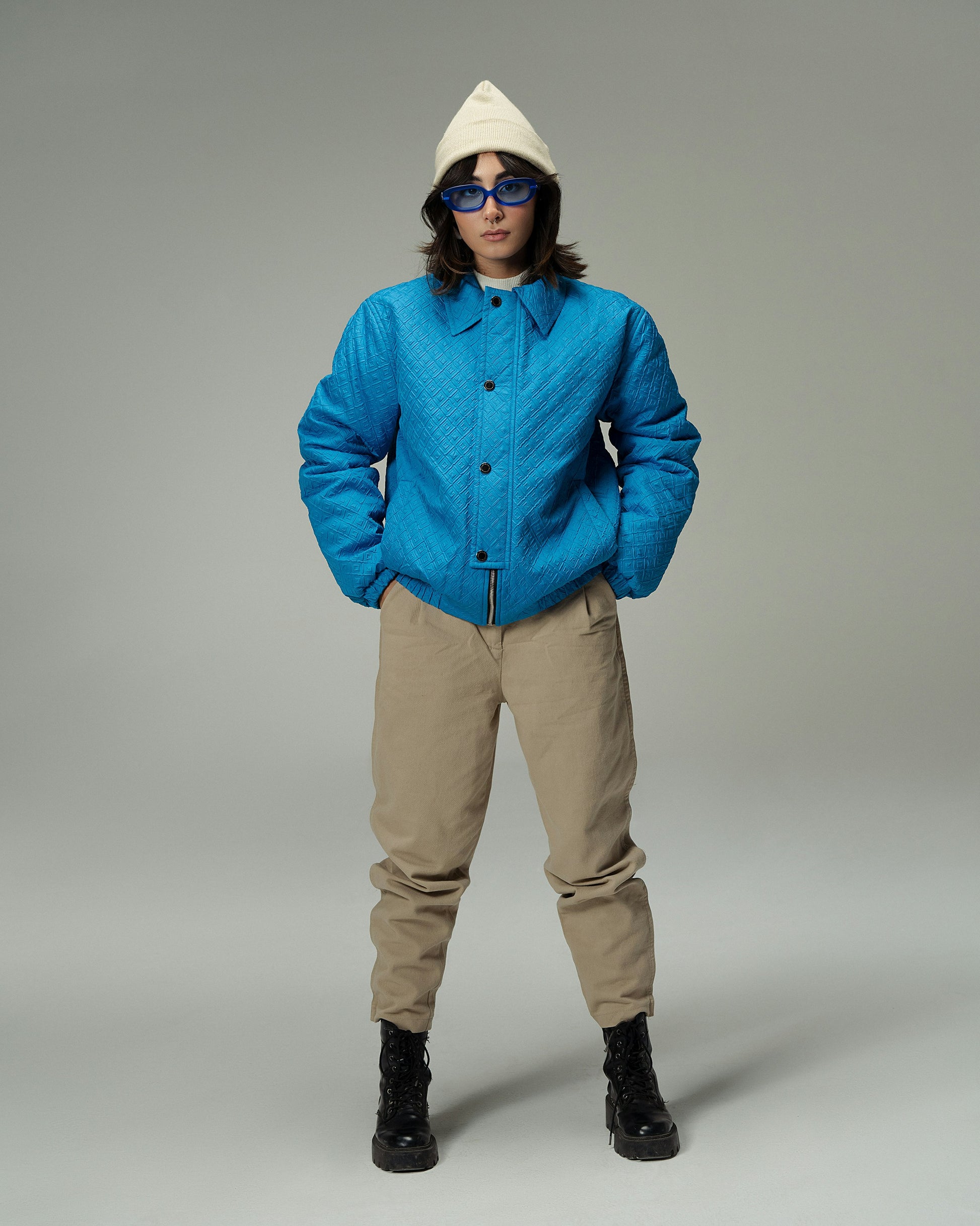 XAYWEAR blue quilted winter jacket worn with beige pants black boots and white hoodie