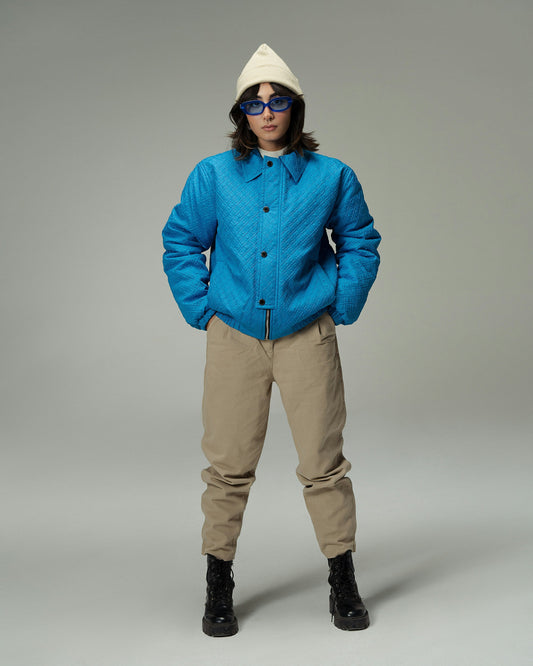 XAYWEAR blue quilted winter jacket styled with beige pants black boots and white beanie