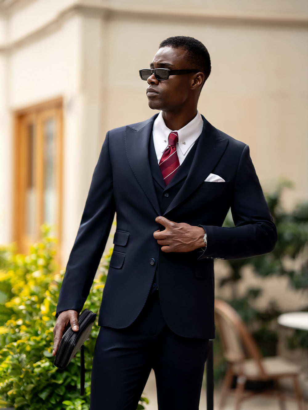 Elegant blue suit for men by XAYWEAR worn with white shirt and red striped tie outdoors