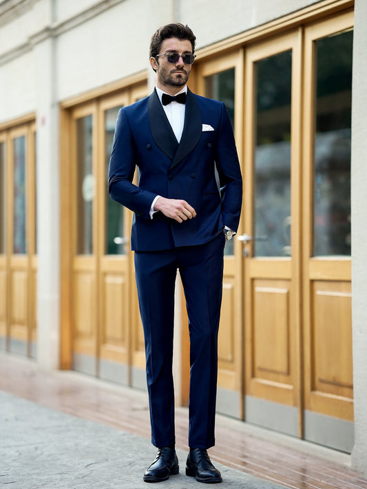 Man wearing stylish XAYWEAR blue suit for men with black lapels and bow tie standing outdoors