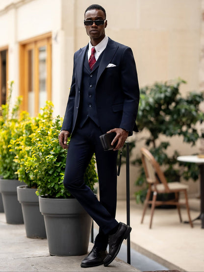 Man wearing a stylish blue suit for men by XAYWEAR with a white shirt, red tie, and black shoes