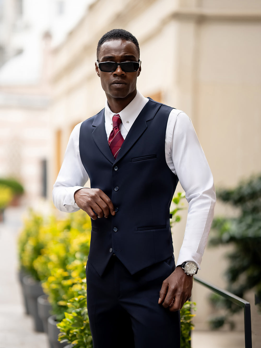 Man wearing a stylish XAYWEAR blue suit for men with a white shirt and red tie outdoors
