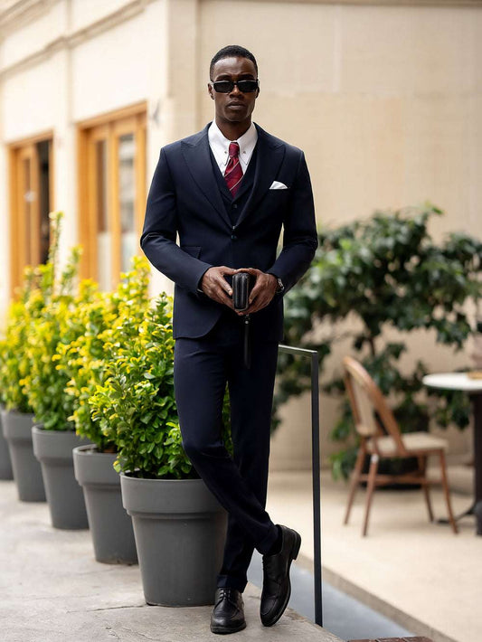 Man wearing a stylish blue suit for men by XAYWEAR with a white pocket square and red tie outdoors