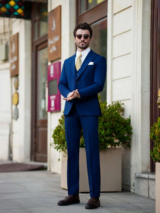 XAYWEAR blue suit worn by man paired with white shirt and gold tie formal wear for men