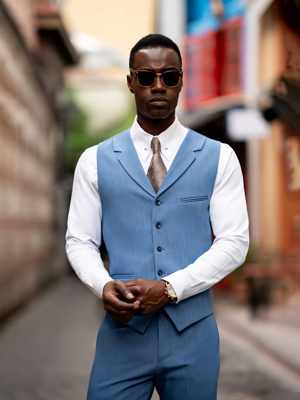 XAYWEAR blue vest suit for men styled with white shirt and brown tie in urban setting
