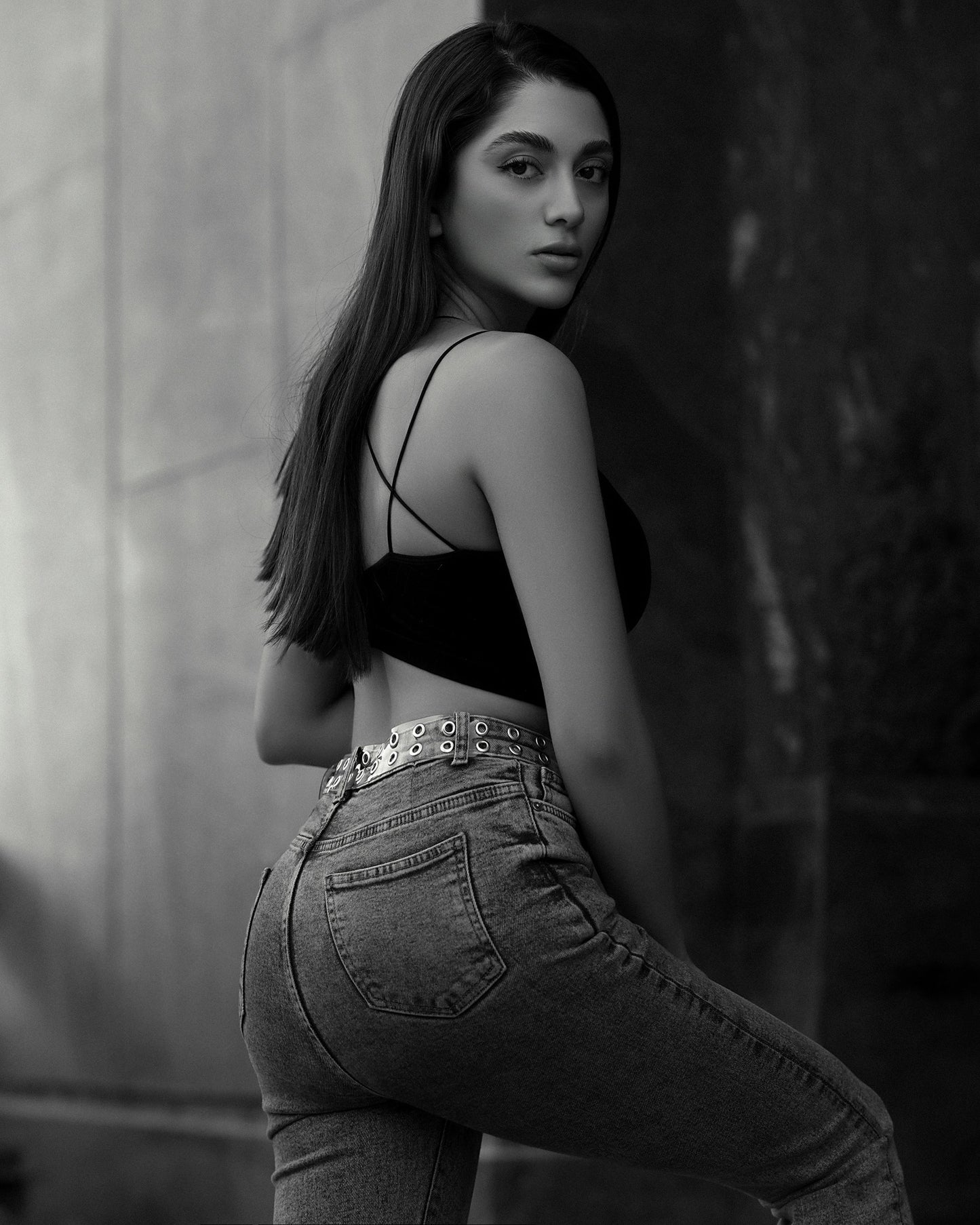 XAYWEAR black crop top with thin straps paired with high-waisted jeans on a female model