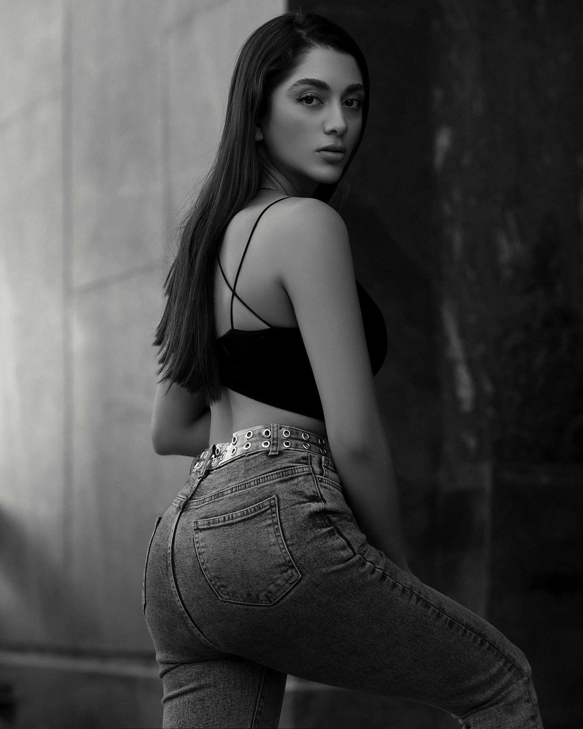 XAYWEAR black crop top with thin straps paired with high-waisted jeans on a female model
