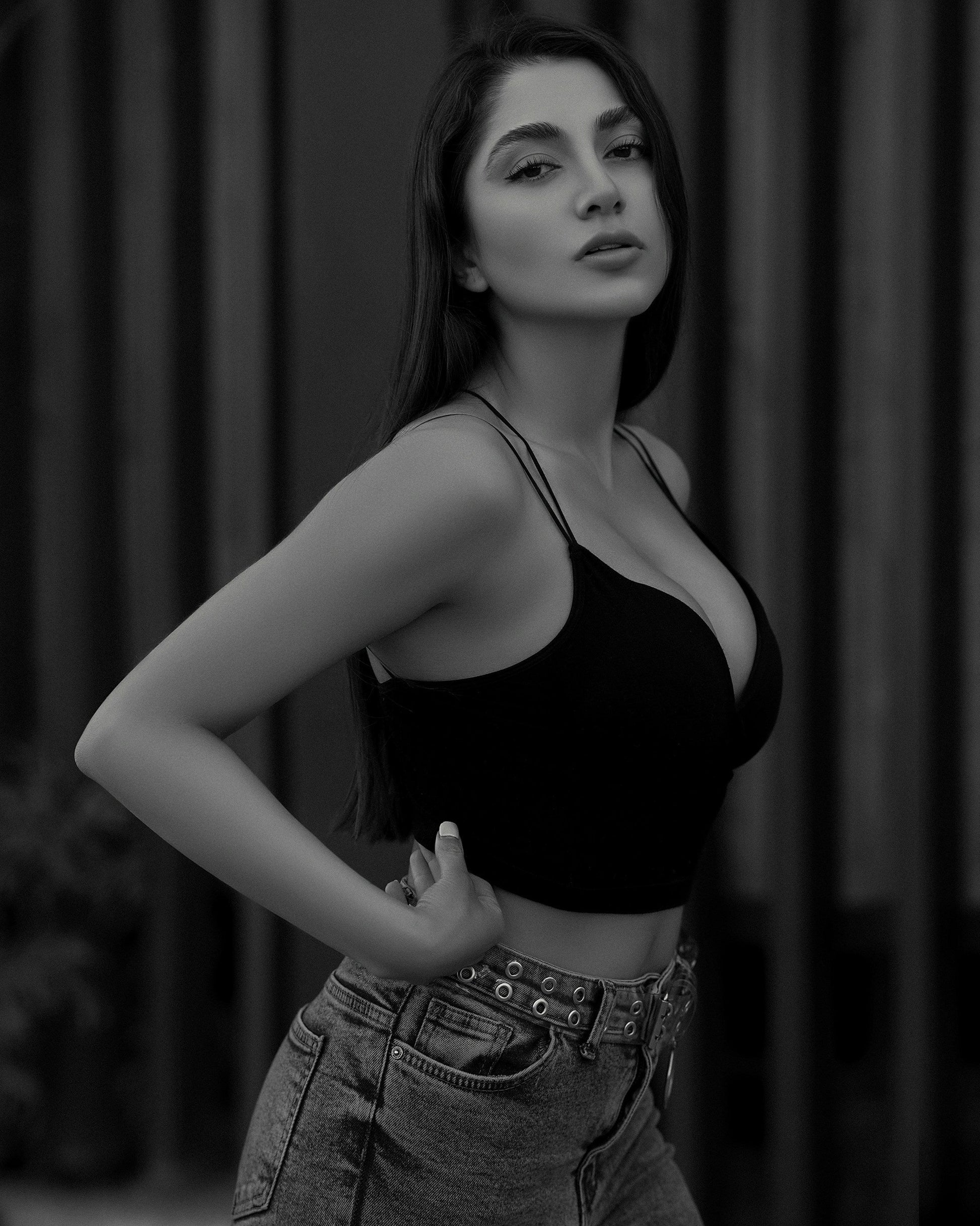 XAYWEAR black crop top with thin straps worn by woman paired with high-waisted denim jeans