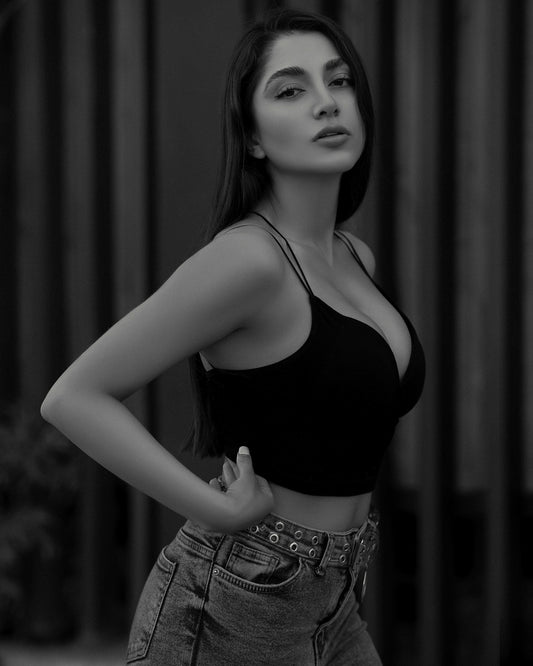 XAYWEAR black crop top with thin straps worn by woman paired with high-waisted denim jeans