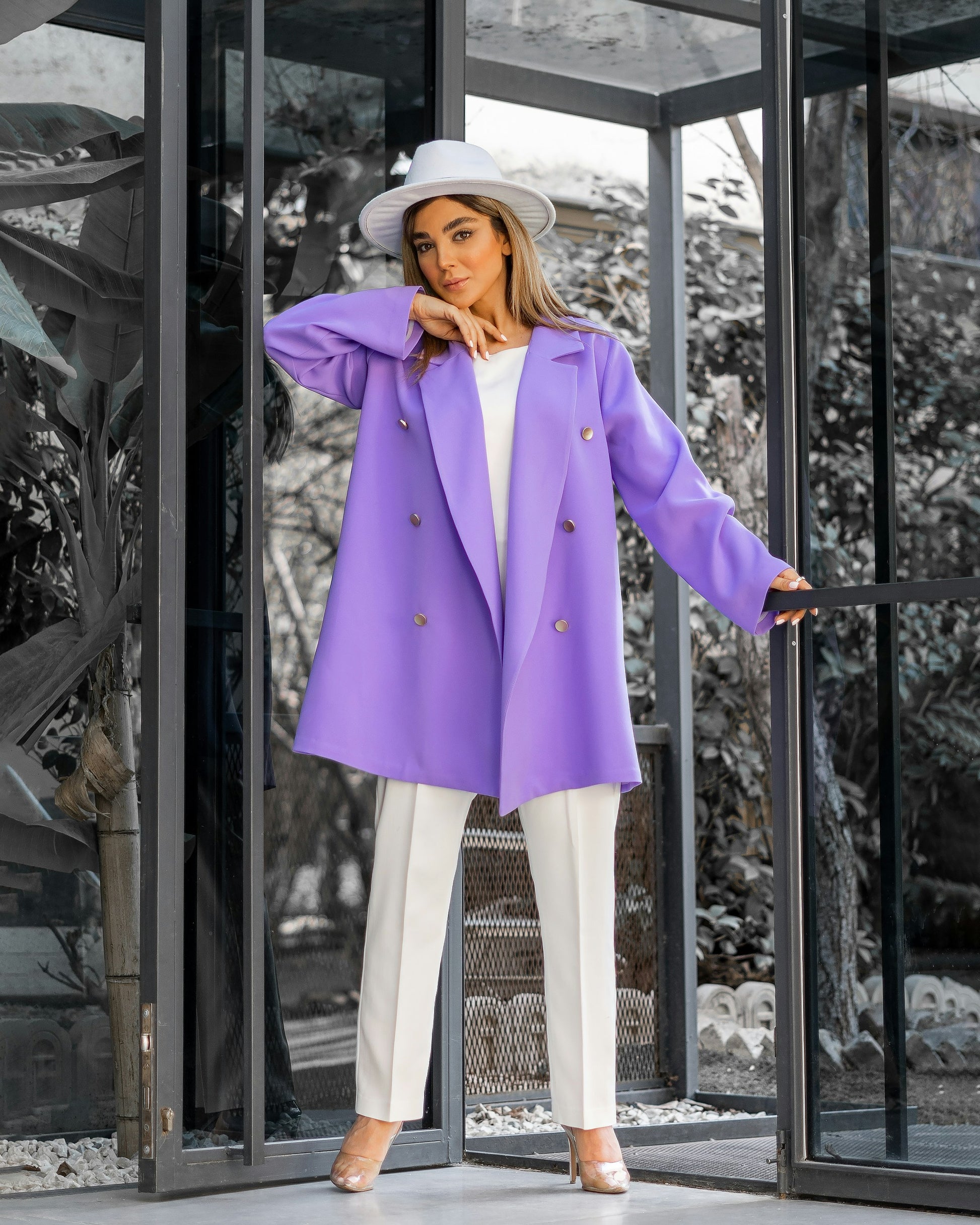 XAYWEAR stylish purple WOMEN COAT worn with white pants and hat in modern glass doorway