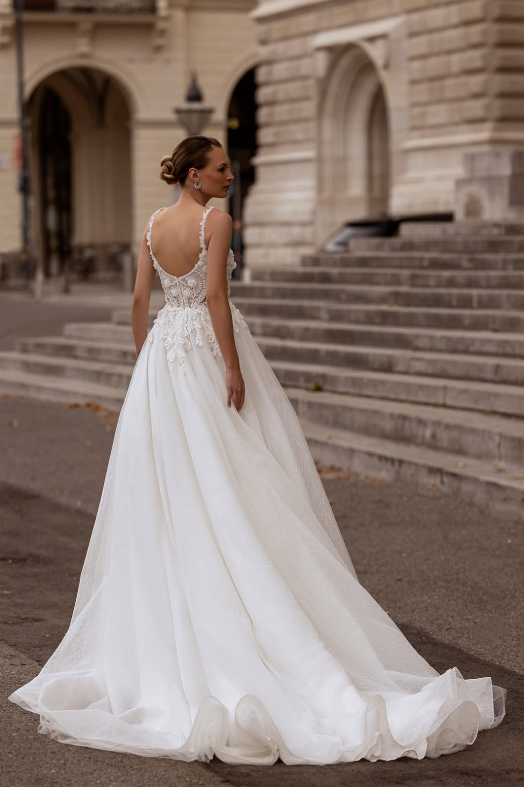 XAYWEAR elegant white bridal gown with lace bodice and flowing skirt worn outdoors by model