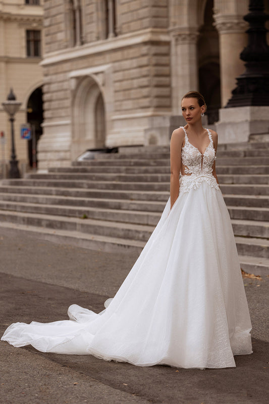 Elegant XAYWEAR bridal gown with lace bodice and flowing tulle skirt worn outdoors on city steps