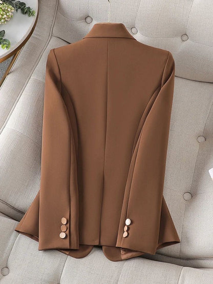 XAYWEAR brown women blazer laid flat on beige tufted sofa showing back design with buttons on sleeves
