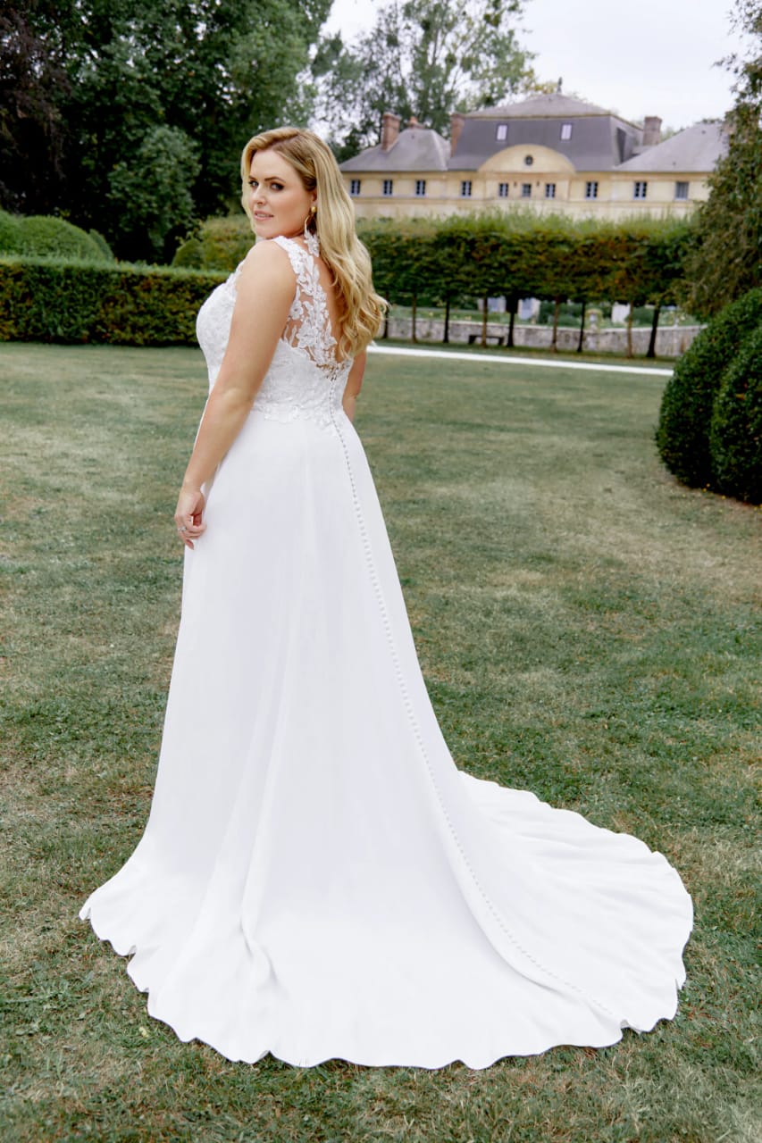 XAYWEAR chiffon wedding gown with lace back and long flowing train on a grassy outdoor background