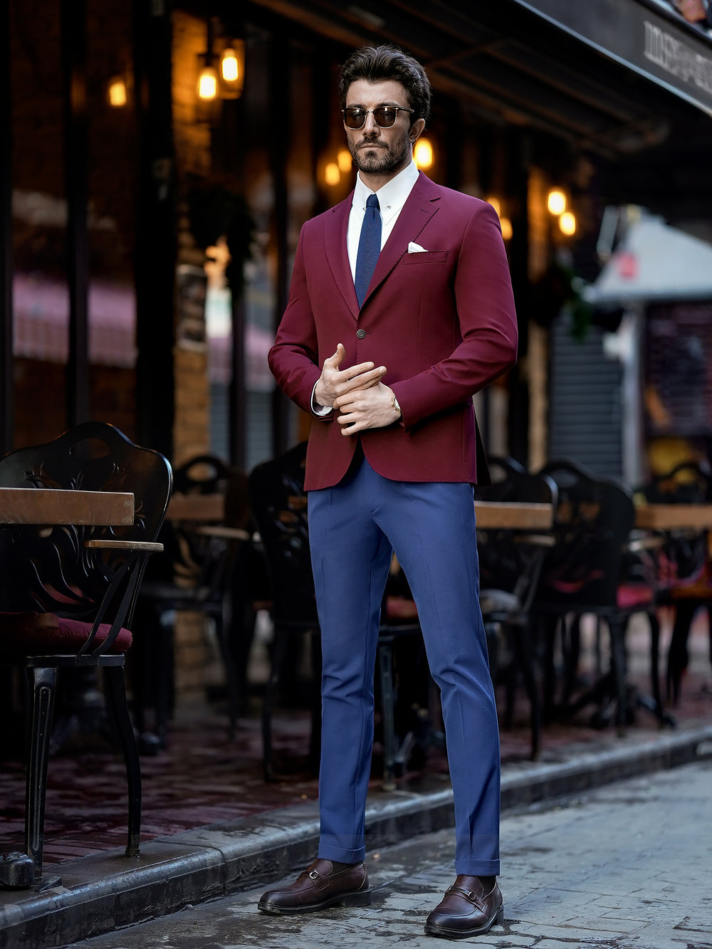 Man wearing a stylish suit for men by XAYWEAR with a burgundy blazer and blue pants outdoors