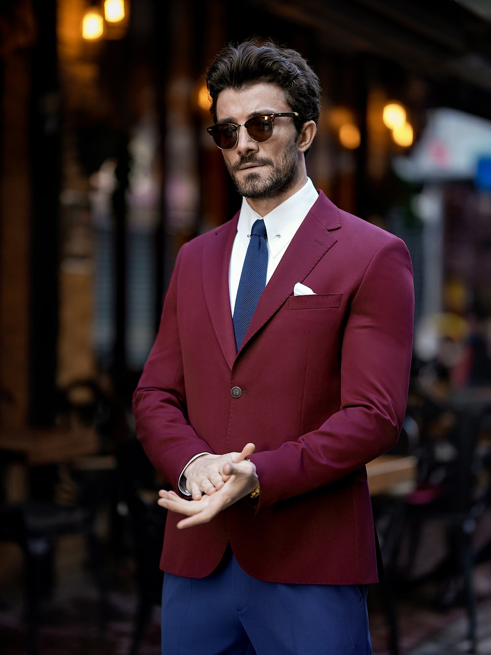 Man wearing a stylish burgundy suit for men with blue pants and sunglasses by XAYWEAR