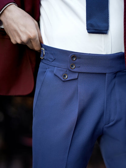 Close-up of blue suit pants for men by XAYWEAR with button and adjustable side buckle detailing