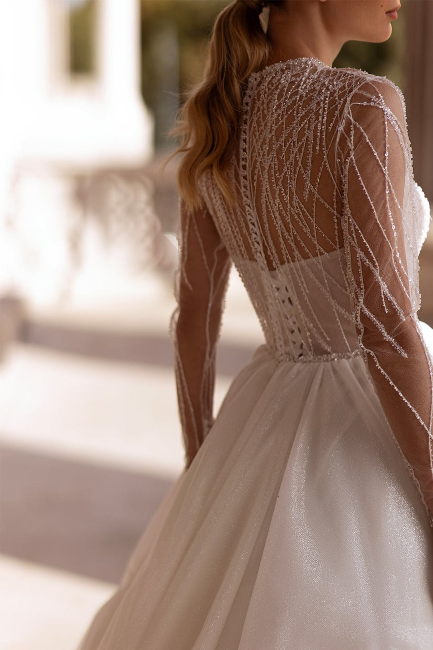 XAYWEAR bridal gown with intricate beaded long sleeves and elegant flowing skirt
